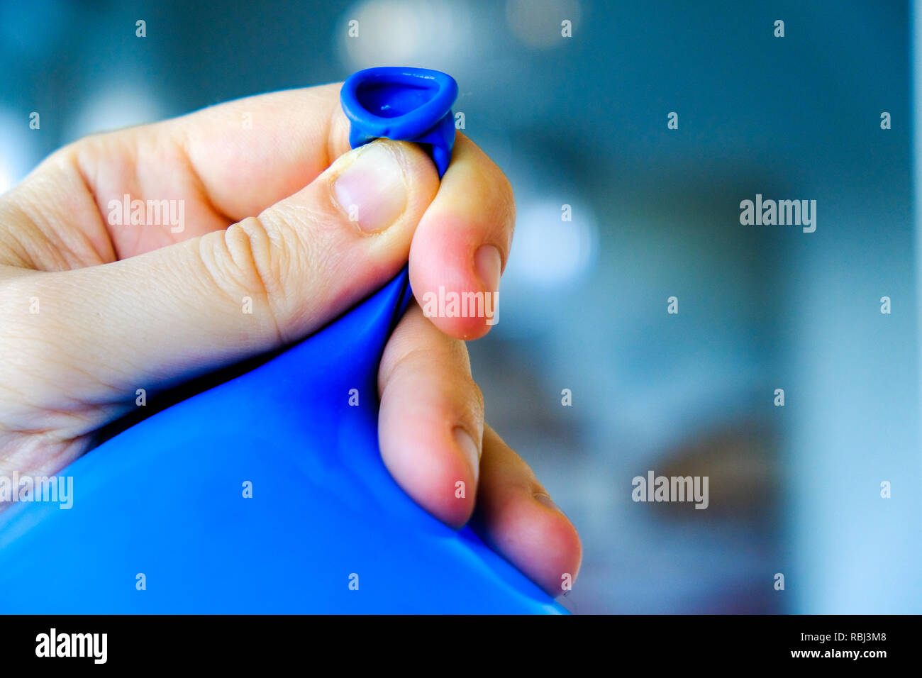 Fascetta a mano a palloncino sfondo blu close up - buttare parte Servizio di preparazione Foto Stock