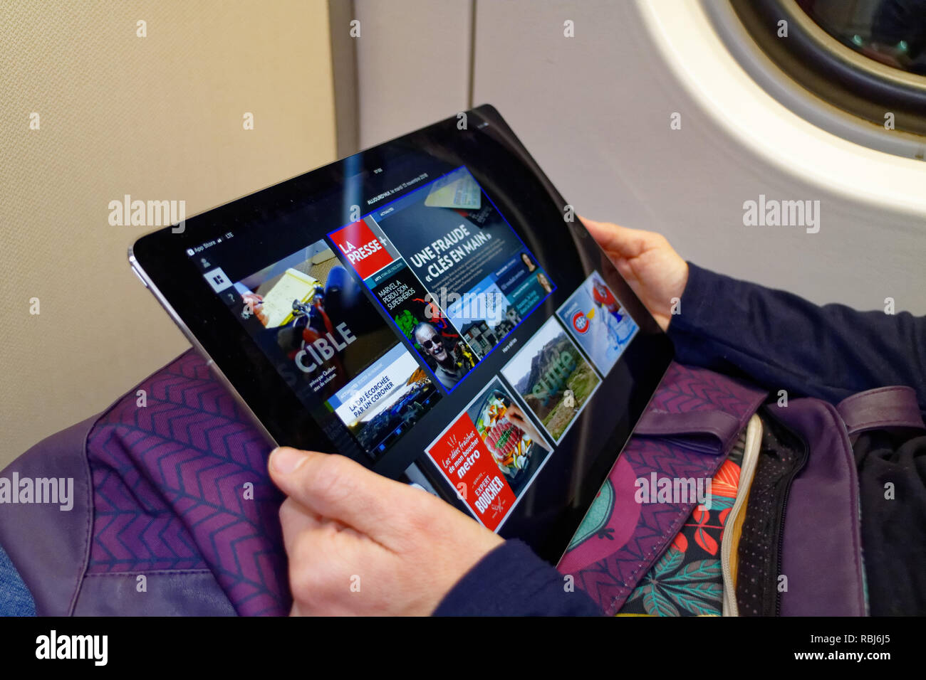 Una donna di mani tenendo un nuovo 12,9 pollici iPad Pro e leggendo il suo giornale Quebec su di esso. Foto Stock