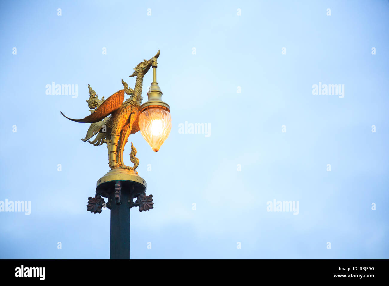 Kanchanaburi, Tailandia - 30 dicembre 2018: Golden Swan Street scultorea lampada in Thai Arte Contemporanea si illumina nel crepuscolo sul Mon ponte in Sangkhlabur Foto Stock