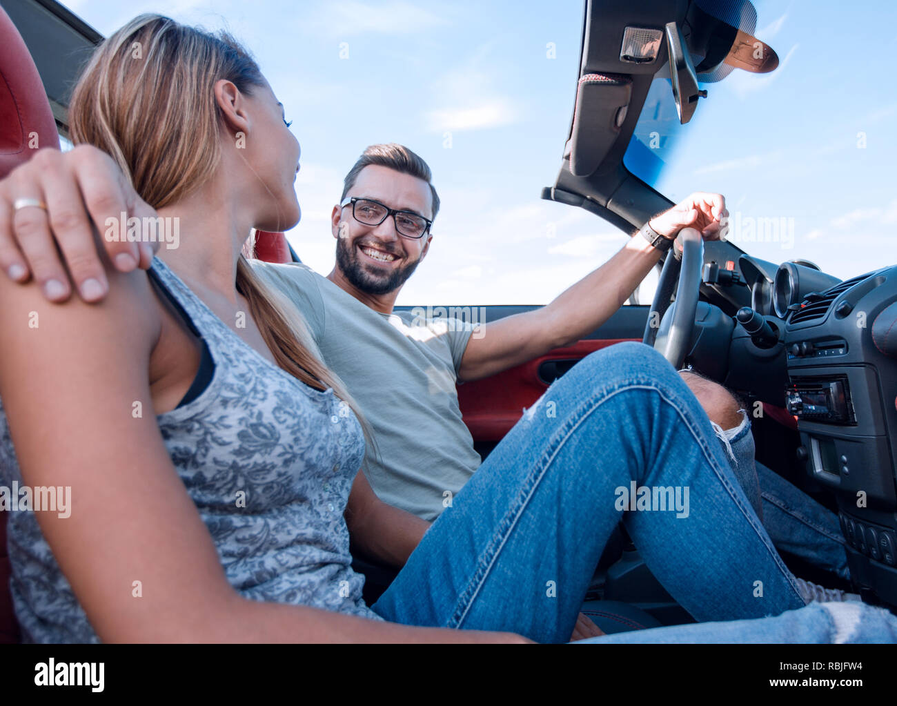 Sposi novelli godendo di un viaggio in una cabriolet Foto Stock