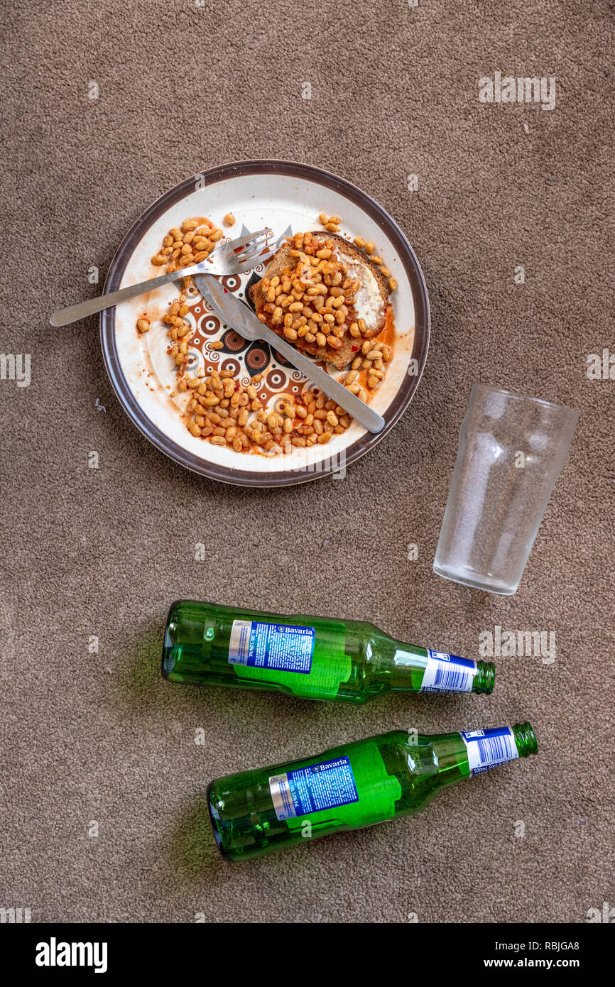 Il pavimento di un appartamento studentesco - congelato fagioli al forno - vetro vuoto - le bottiglie di birra Foto Stock