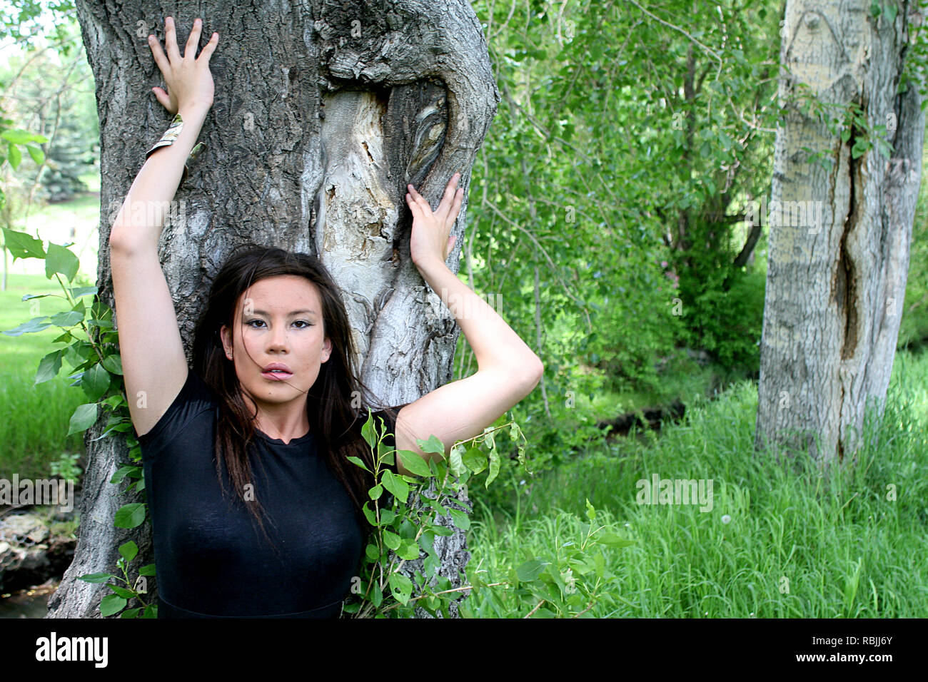 Bella bruna ragazza divertirsi tra gli alberi e la foresta Foto Stock