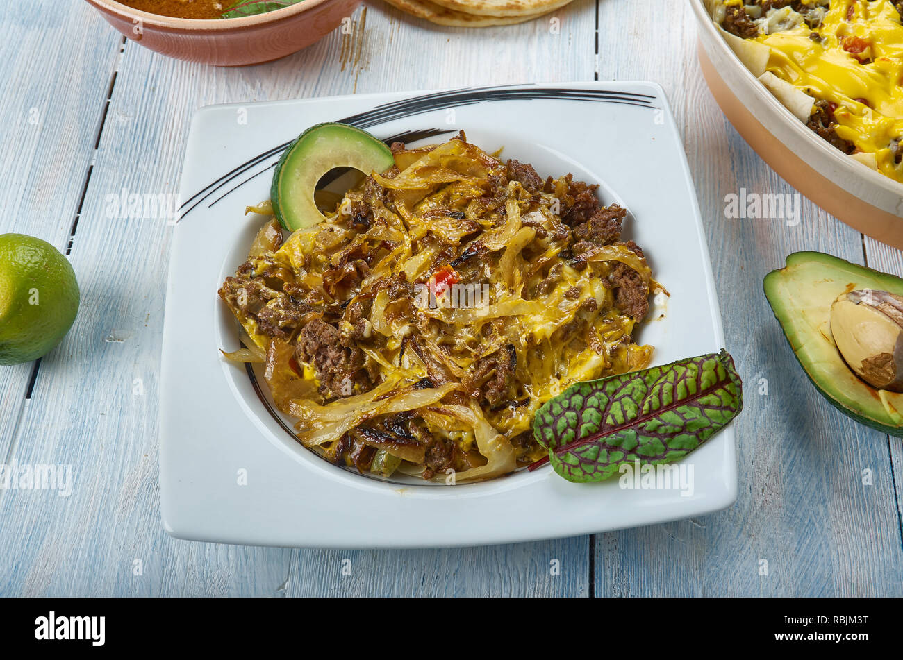 Tex Mex cavolo padella Carni bovine oppato con messicano piccante miscela di formaggio, cucina tex-mex e tradizionali piatti assortiti, vista dall'alto. Foto Stock