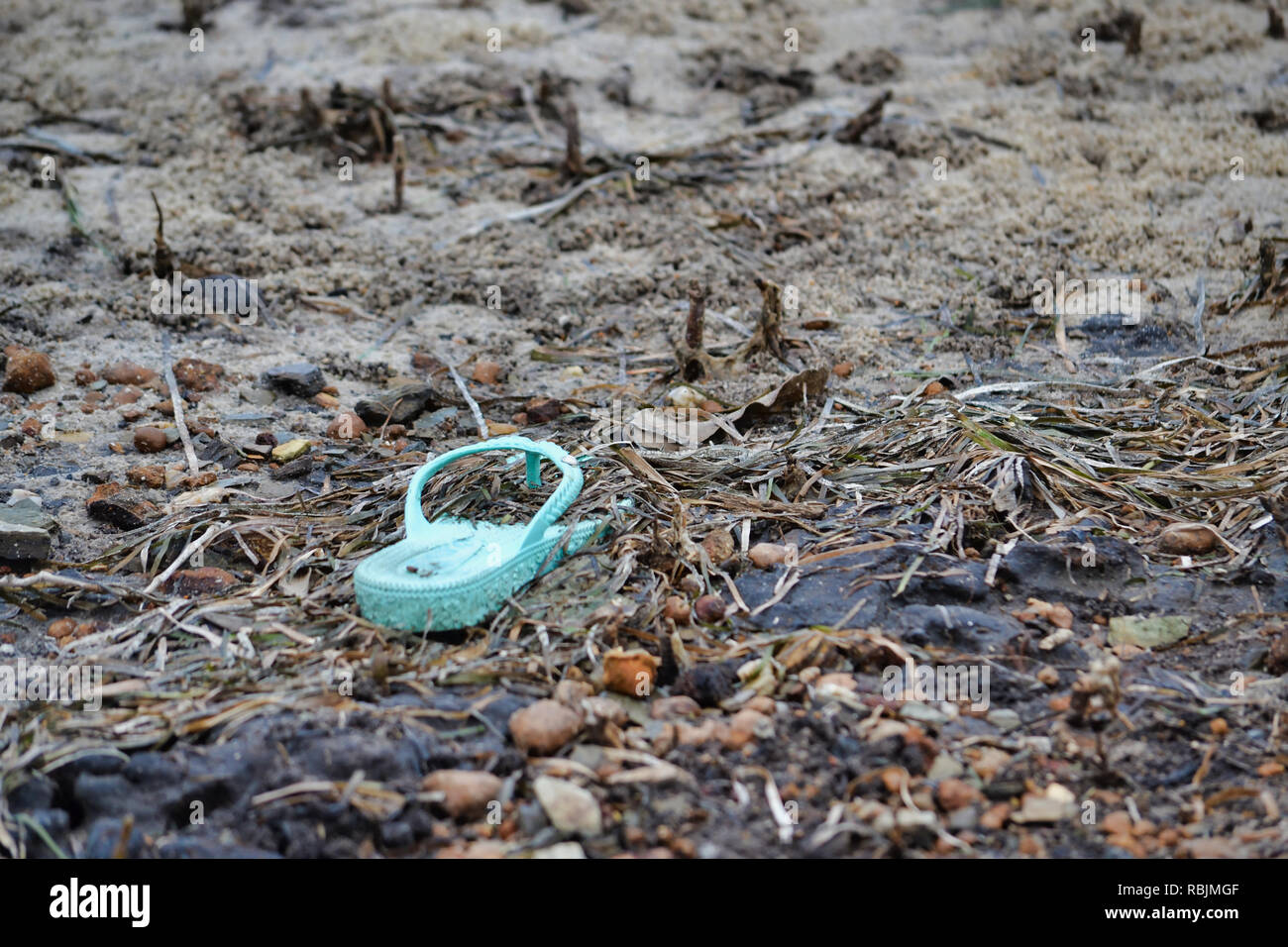 Una gomma di lone flip flop lavaggi a terra Foto Stock