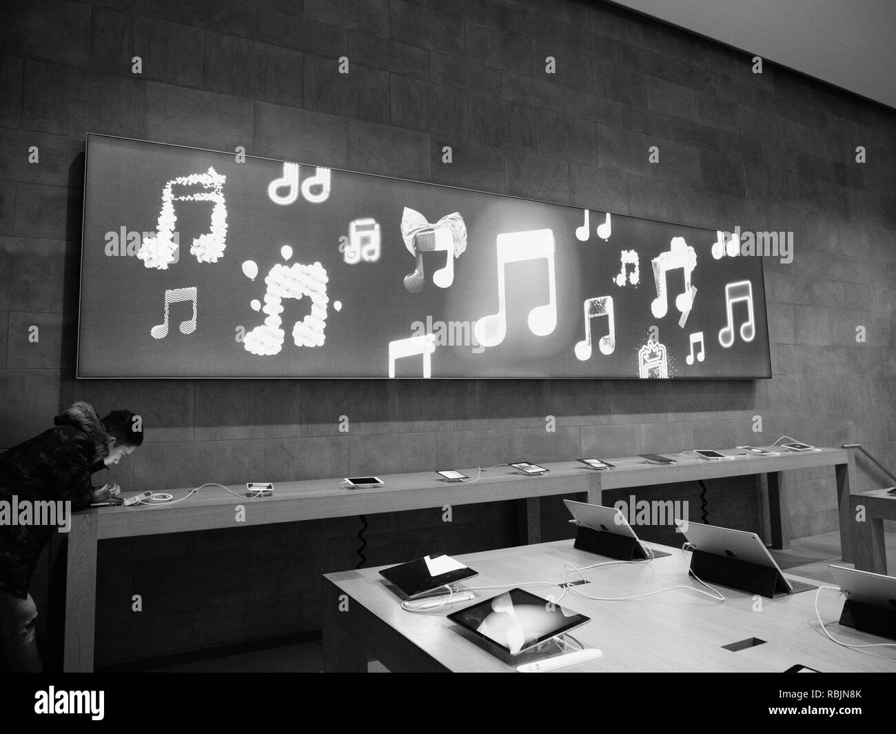 Strasburgo, Francia - Jan 10, 2018: maschio curioso ammirando il Macbook Pro Apple computer portatile in Apple Store - bianco e nero Foto Stock
