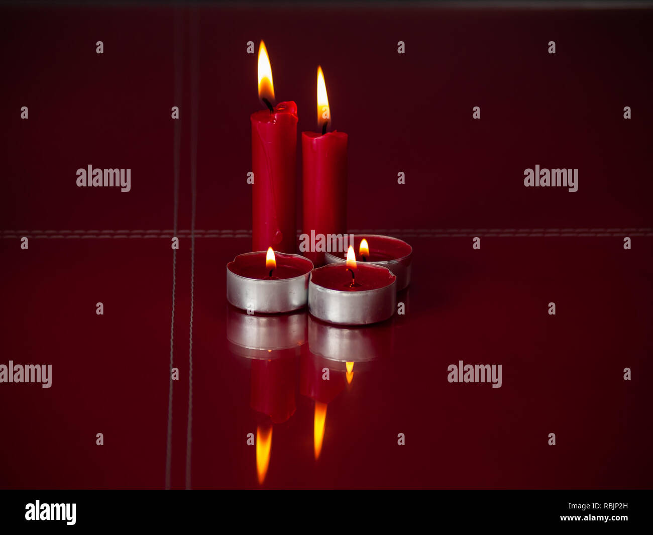 Concetto di amore candele rosse accese con sfondo grigio Foto Stock