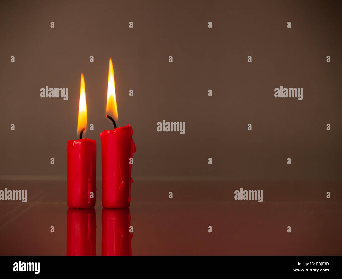 Concetto di amore candele rosse accese con un sfondo caldo Foto Stock