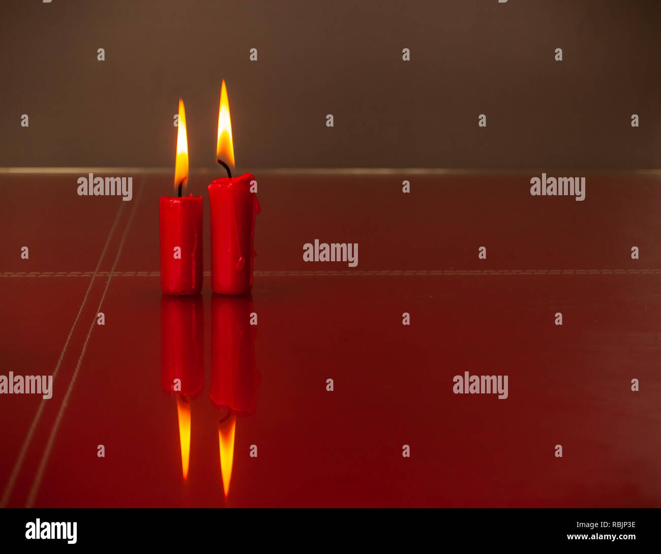 Concetto di amore candele rosse accese con un sfondo caldo Foto Stock