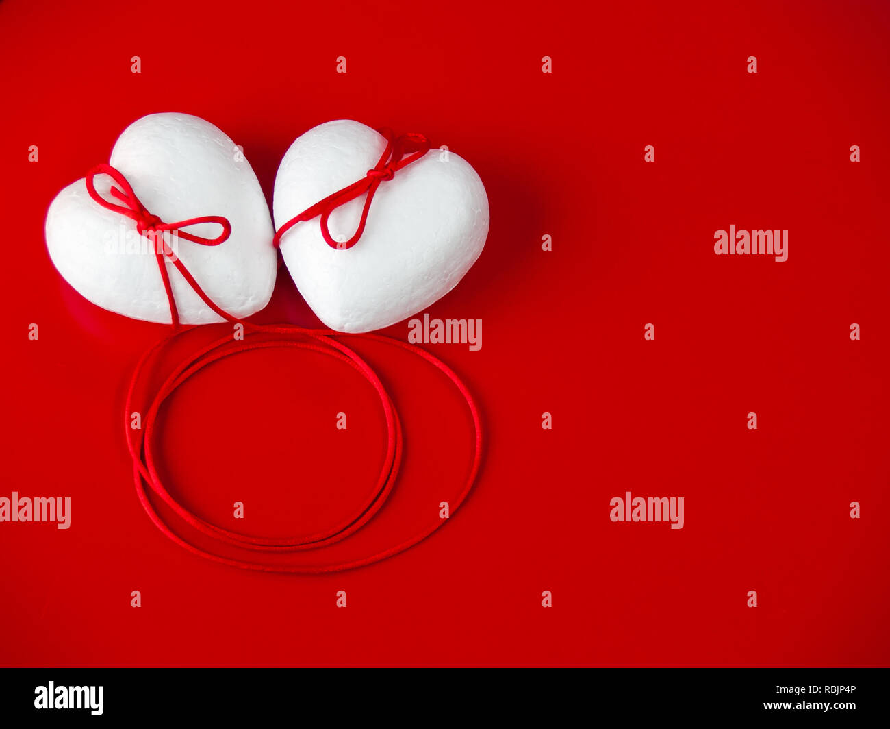 Concetto di amore poliespan due cuori uniti con un filo rosso che  simboleggia la leggenda del filo rosso Foto stock - Alamy