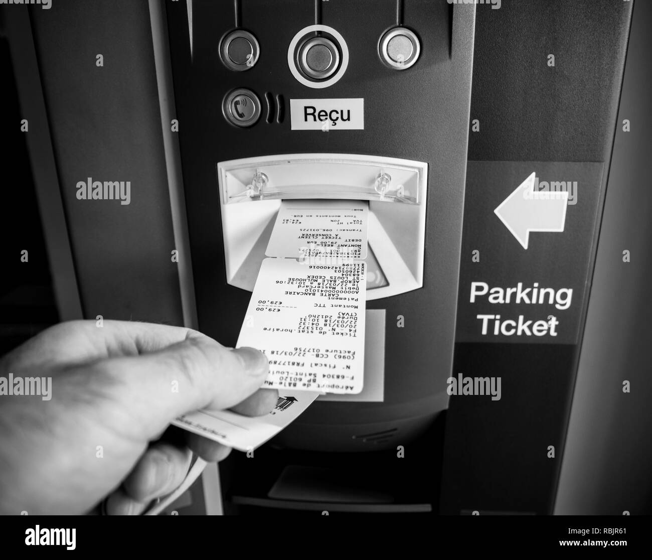 BASEL, Svizzera - Mar 22, 2018: il punto di vista della mano maschio tenendo il biglietto e la fattura dal moderno parcheggio teller machine - bianco e nero Foto Stock