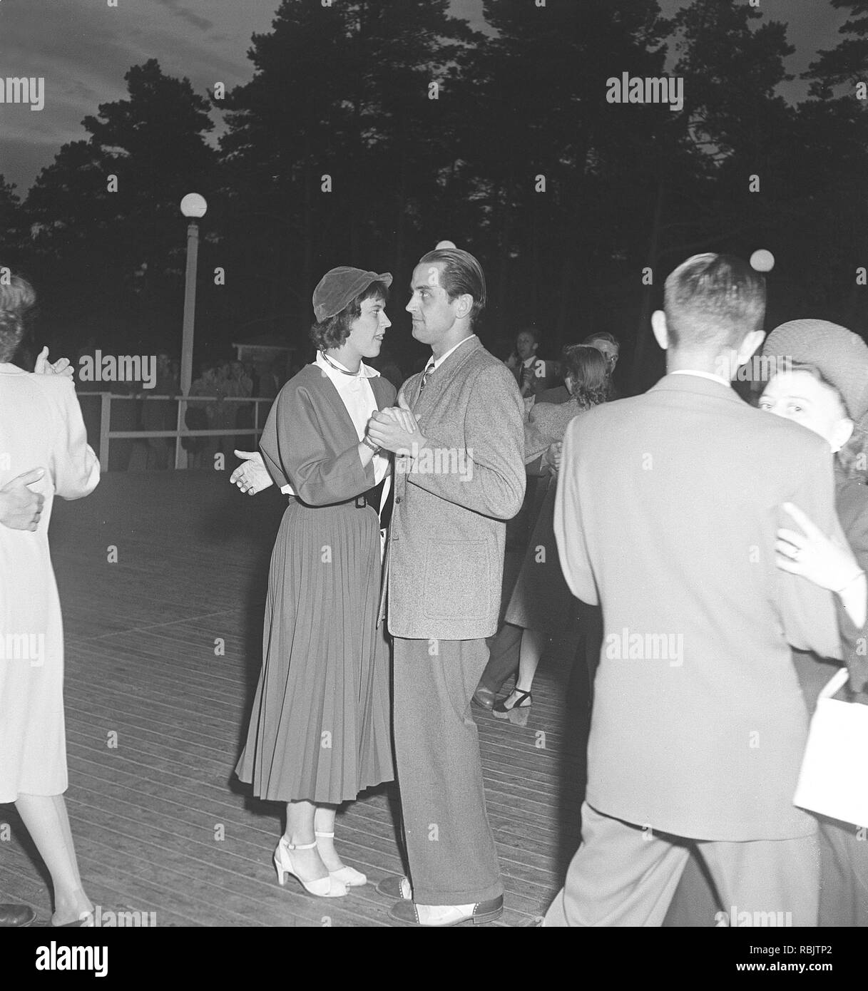 In ballo nel 1940s. Una giovane coppia in una danza azienda ogni altro chiudere muovendosi per la musica a un evento di ballo. Foto Kristoffersson Ref come22-6. La Svezia 1940s Foto Stock