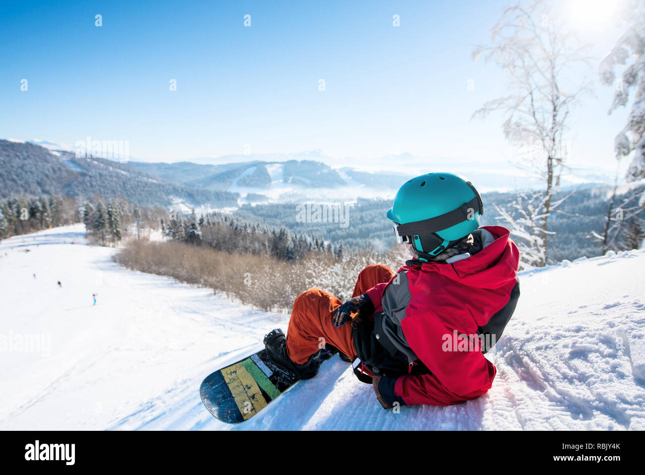 Specchietto colpo di un uomo rilassato snowboarder giacente sul pendio nevoso godendo di splendide montagne vista dopo riposo in sella alla winter resort paesaggio copyspace ricreative attività dello stile di vita Foto Stock