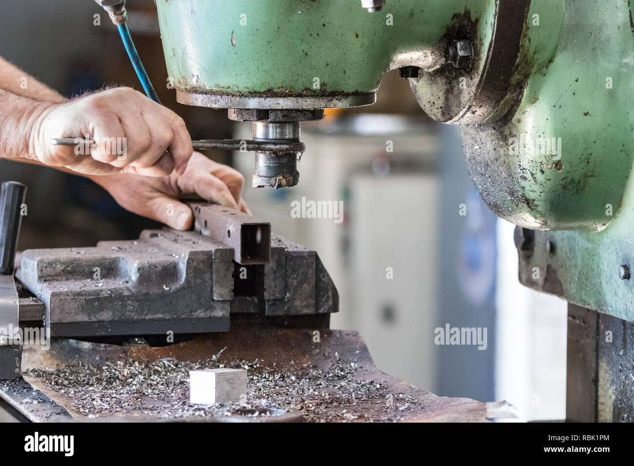 Un lavoratore di sesso maschile operando una fresa drill macchina all'interno di una fabbrica aluminiun. Foto Stock