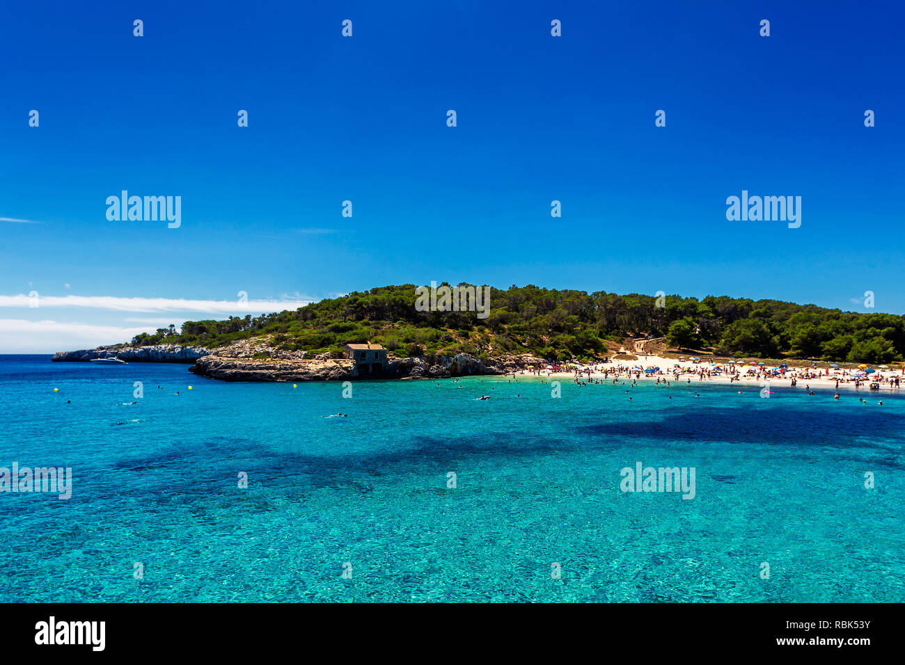 Bellissima spiaggia con acque turchesi affollate di turisti in Cala Mondrago, Mallorca Foto Stock