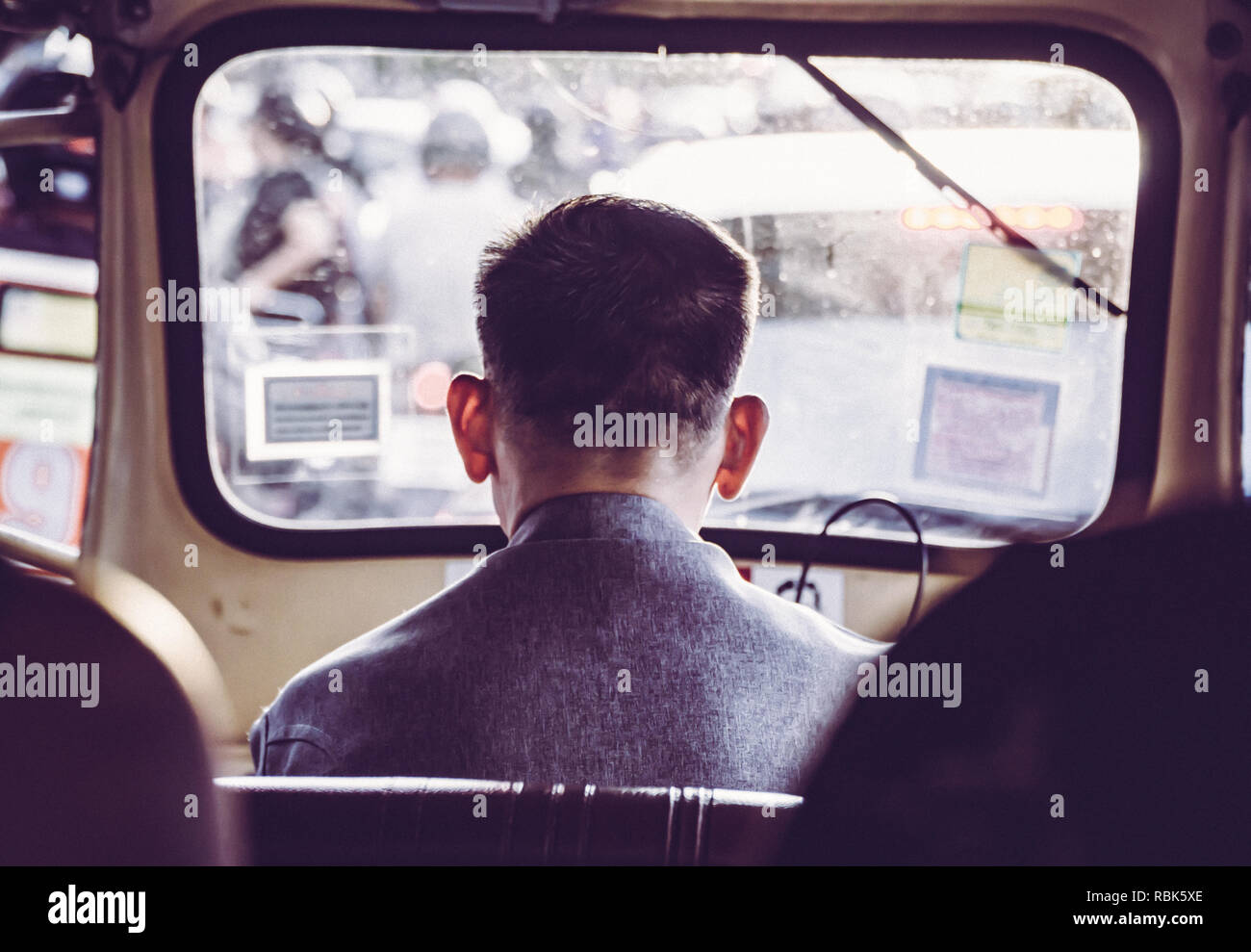 Un Tuk Tuk taxi driver da dietro a Bangkok in Tailandia. Foto Stock