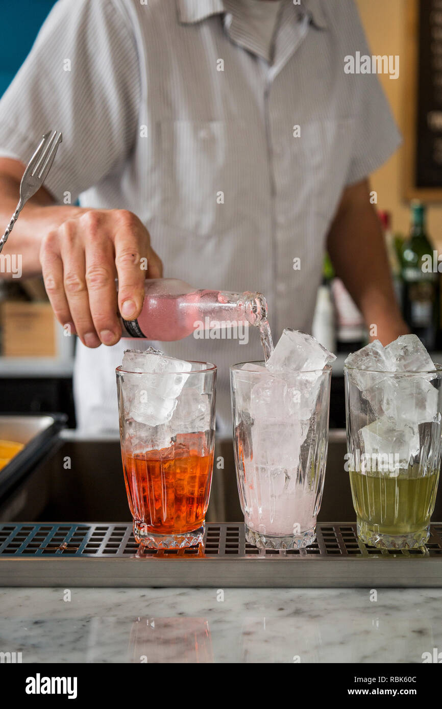 Barista rendendo cocktail in un ristorante Foto Stock