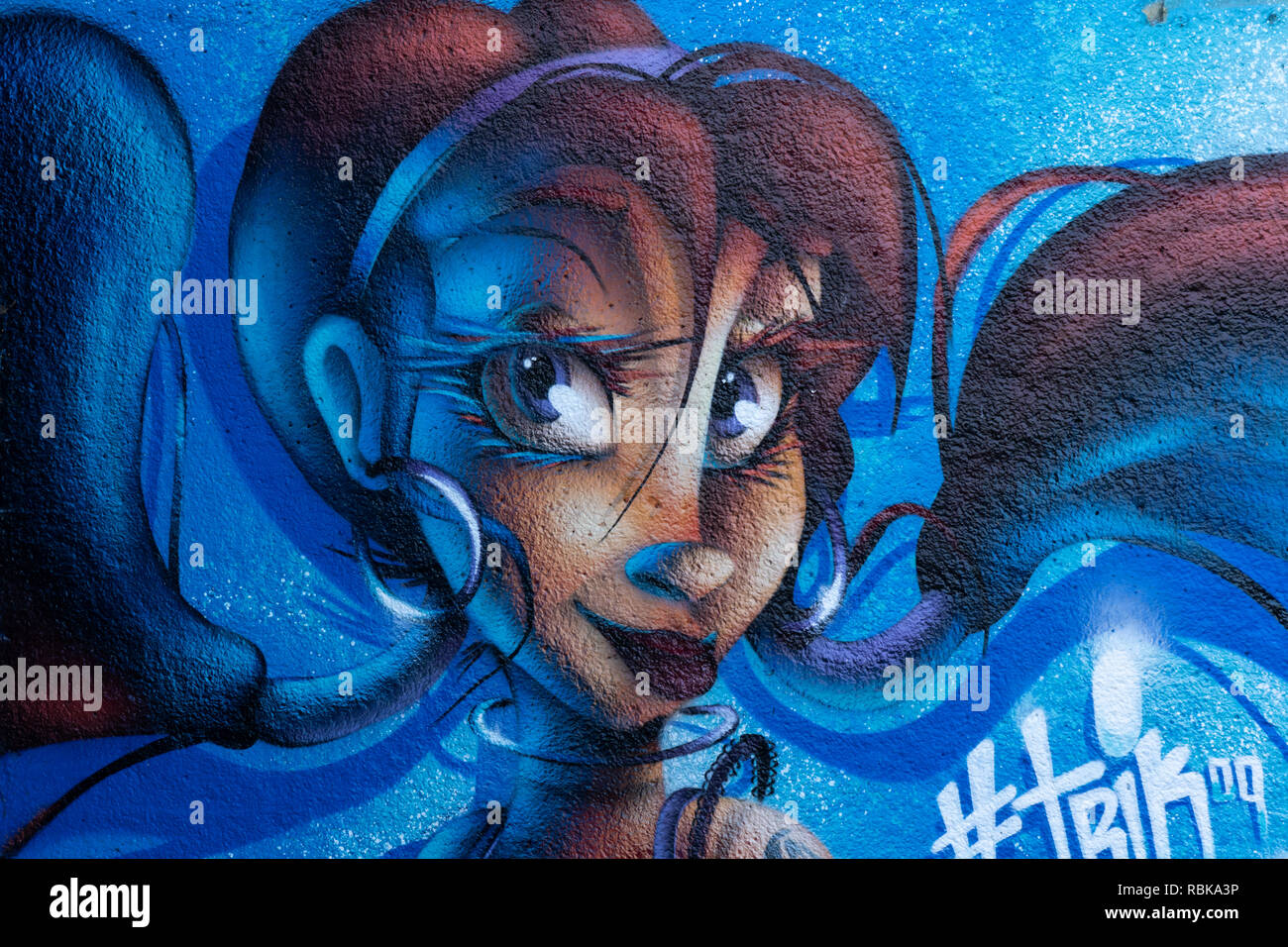 Cartone animato come spray viso donna dipinto su un muro lungo un canale a Leeds, West Yorkshire, Inghilterra. Foto Stock