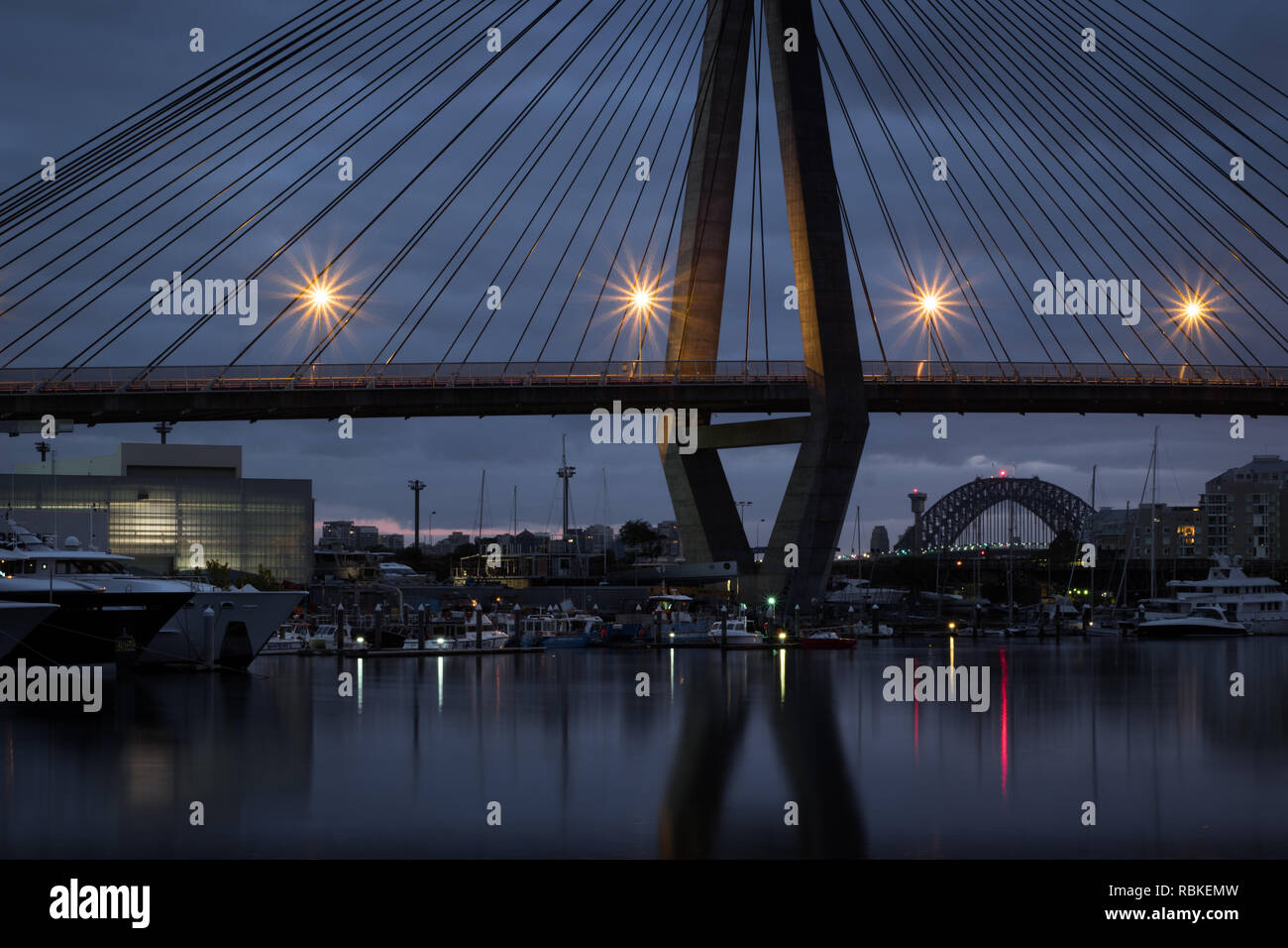 Il Ponte del Porto di Sydney annidato sotto il ponte di Anzac su una mattina nuvoloso Foto Stock