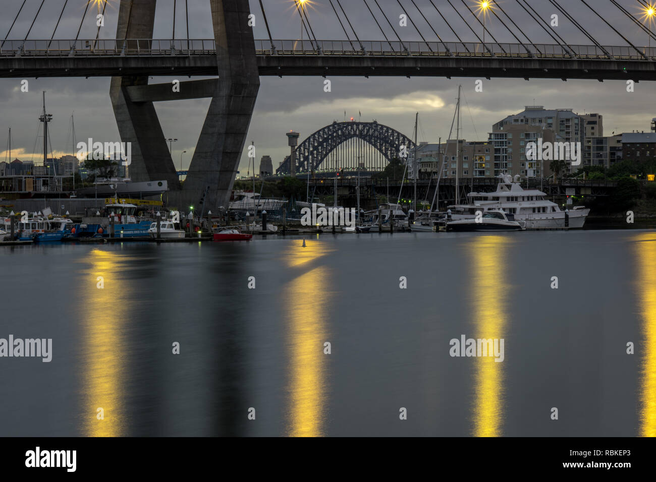 Il Ponte del Porto di Sydney annidato sotto il ponte di Anzac su una mattina nuvoloso Foto Stock