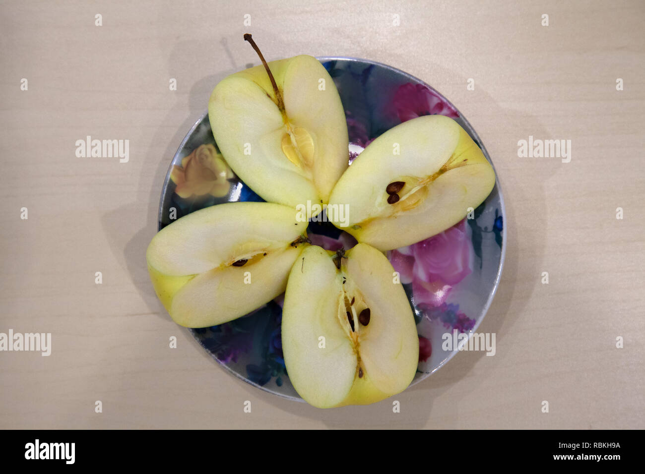 physicist Recount order Una mela verde tagliato in quattro pezzi su una piastra di colore dopo il  raccolto in autunno. Frutta fresca per la produzione di succhi di frutta  Foto stock - Alamy