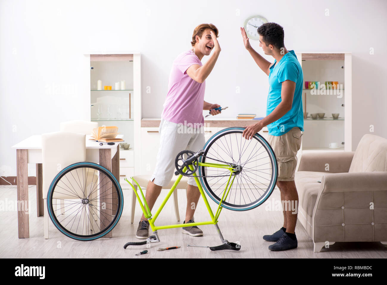 Uomo che ripara la sua bicicletta rotto Foto Stock