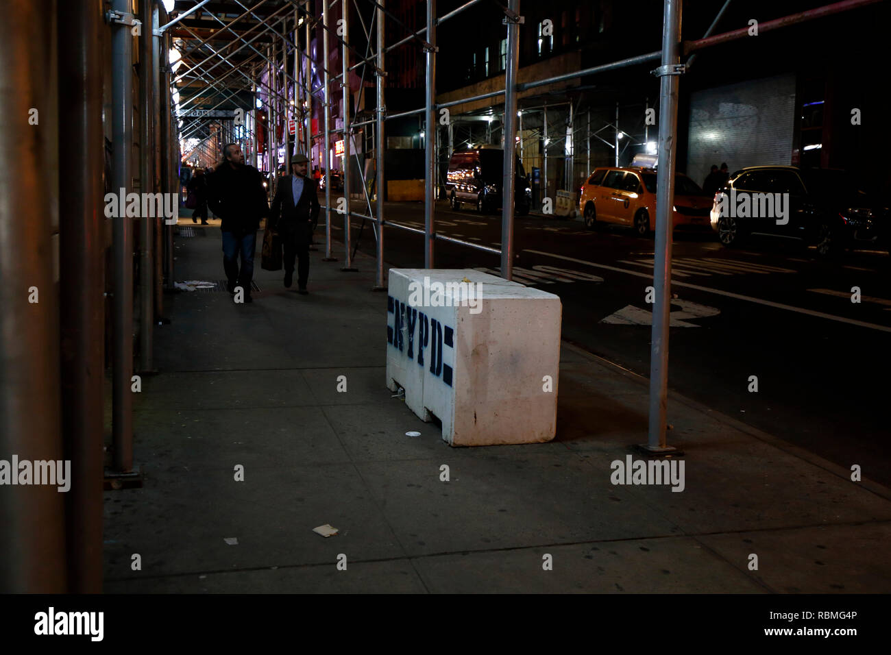 A New York City il marciapiede ristretto con costruzione di ponteggi e barriere di polizia Foto Stock