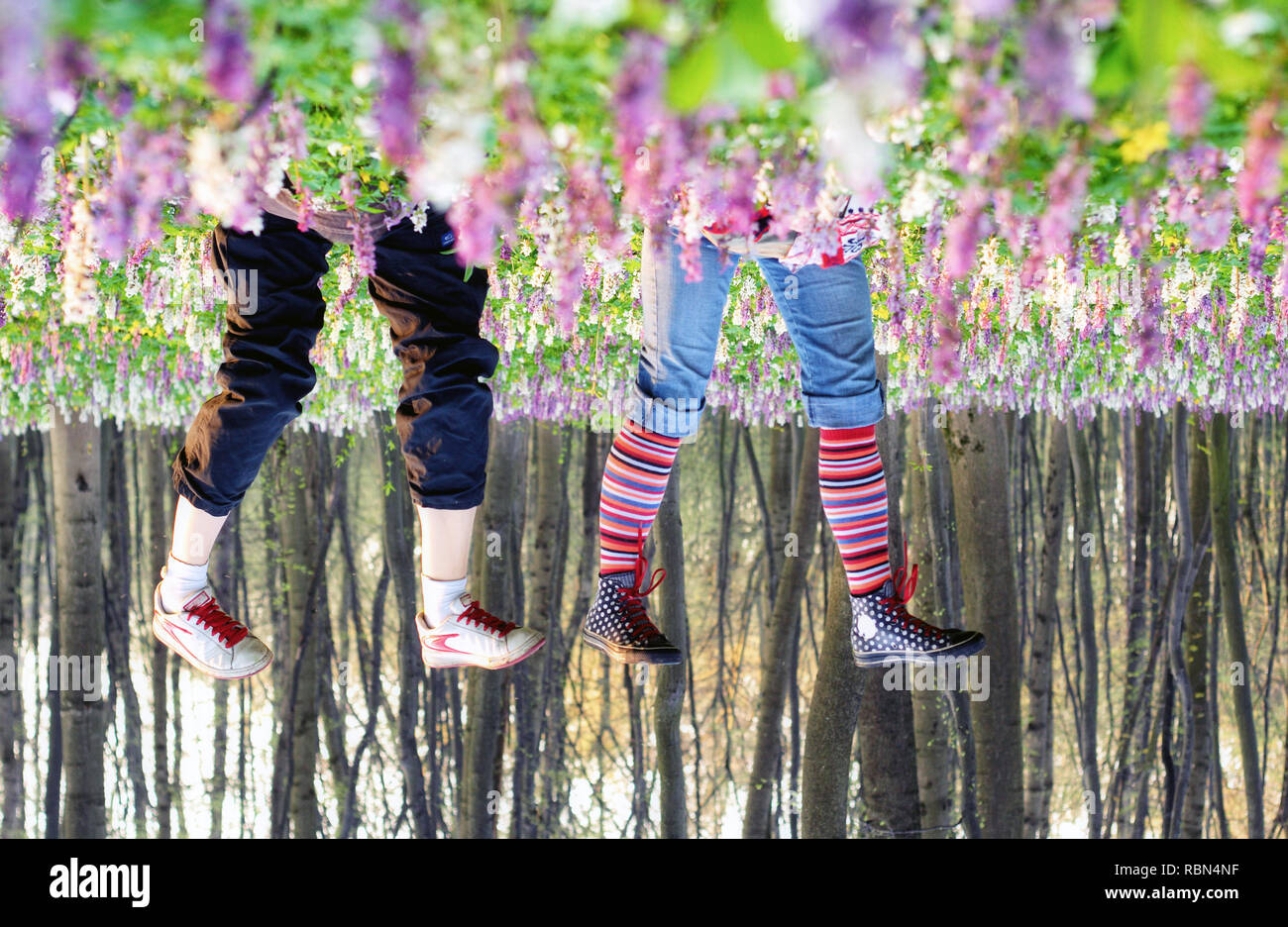 Due ragazze giacente in fioritura di prato. Foto concettuale. La primavera è alle porte. Il pittoresco e una stupenda scena. Scoprite il mondo della bellezza. Foto Stock