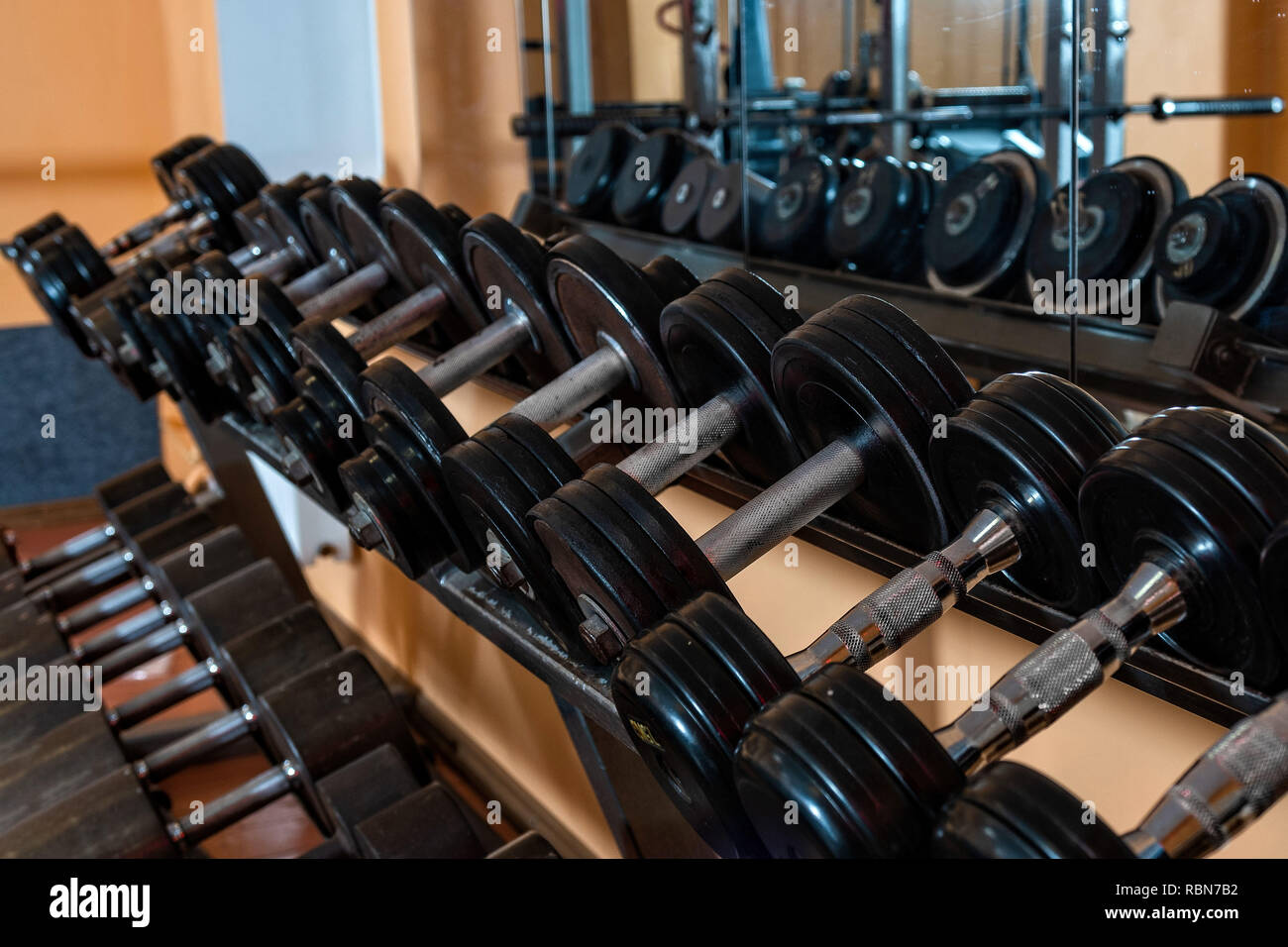 Righe di metallo manubri su rack in palestra / sport club. Peso attrezzatura di formazione. - Immagine Foto Stock