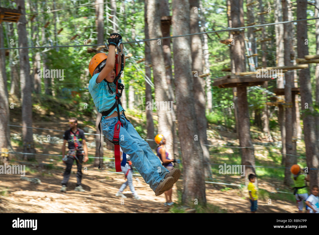 Ragazzo con cablaggio di sicurezza arrampicate nel parco avventura in pineta. Guardiagrele, .Abruzzo, Italia Foto Stock