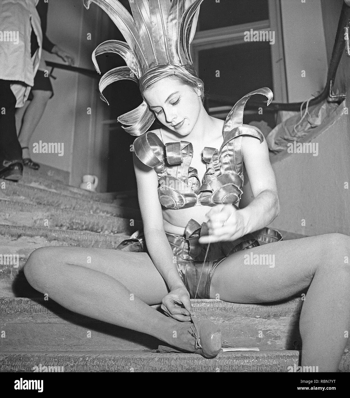 Ballerina nel 1940s. Una giovane donna nella sua fase costume è seduto in scala dietro il palco e le riparazioni le scarpe da ballo. La Svezia 1946 Photo Kristoffersson ref X134-3 Foto Stock