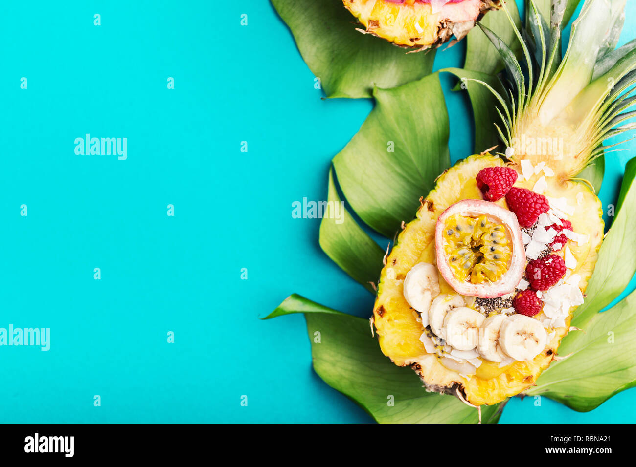 Gustoso frullato di appetitosi bocce servita in metà ananas decorato con taglio frutto della passione, scaglie di noce di cocco e semi di chia.la vita sana pulire mangiare co Foto Stock