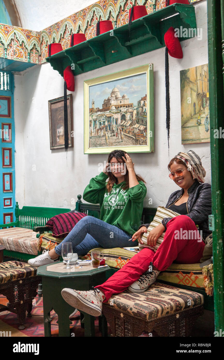 Due ragazze che si godono rinfreschi in un caffè a Medina Foto Stock