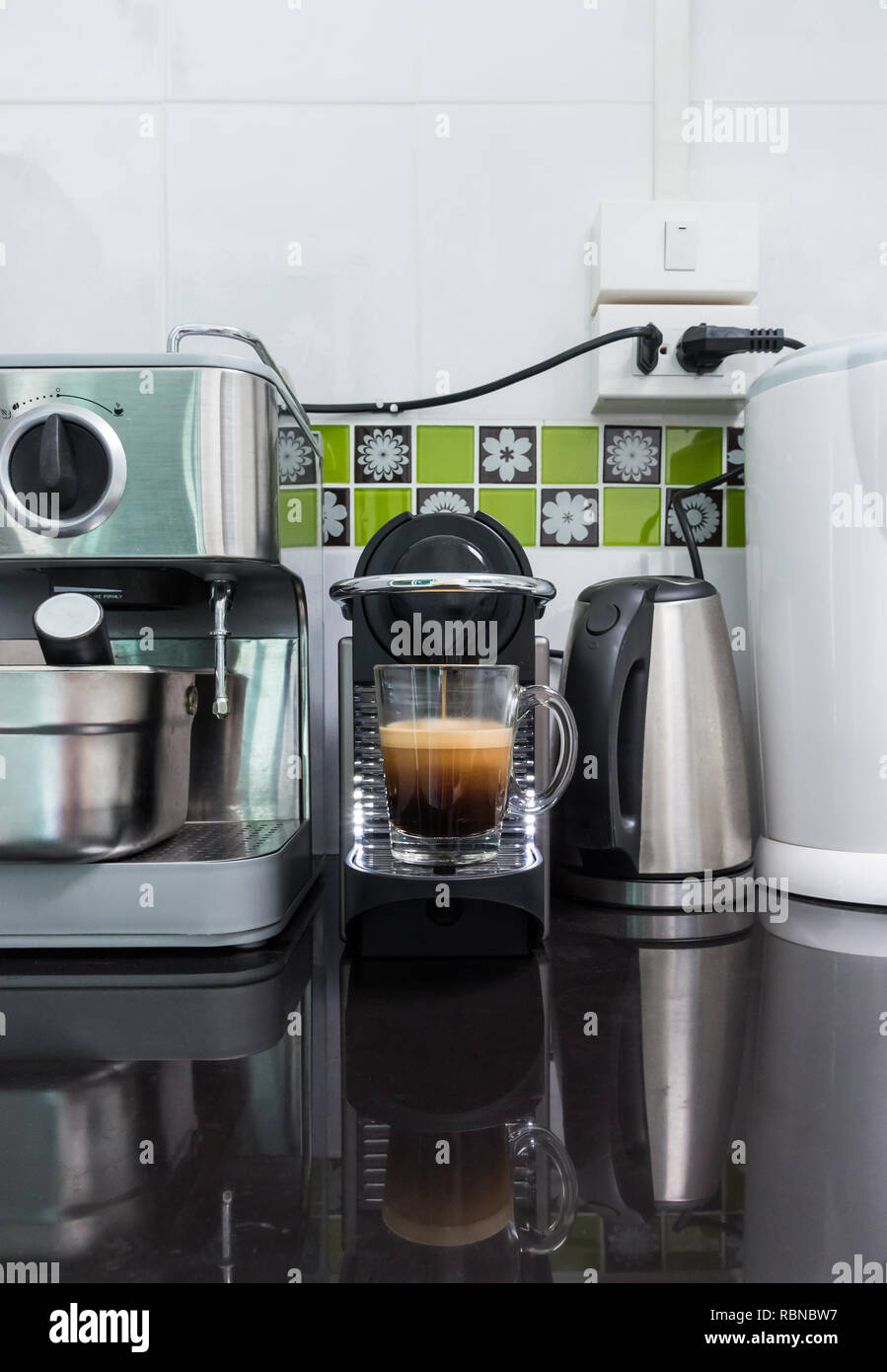 Piccola macchina per caffè è rendere il caffè espresso con le capsule sistema sulla parte superiore del banco bar in cucina. Foto Stock