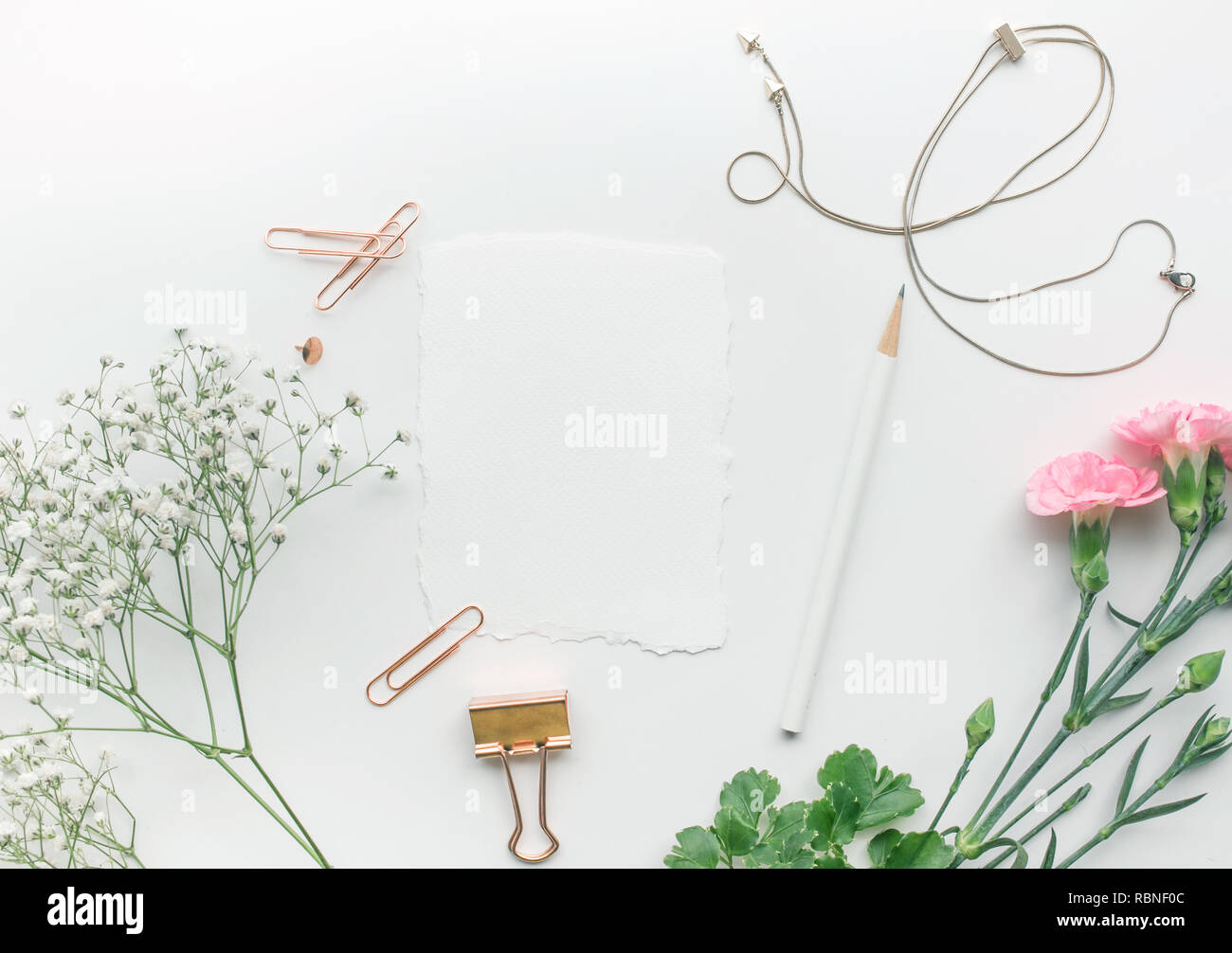 Home office desk tabella con nota della carta,fiore su sfondo bianco.Flat lay.concetti femminile design.stile minimalista Foto Stock