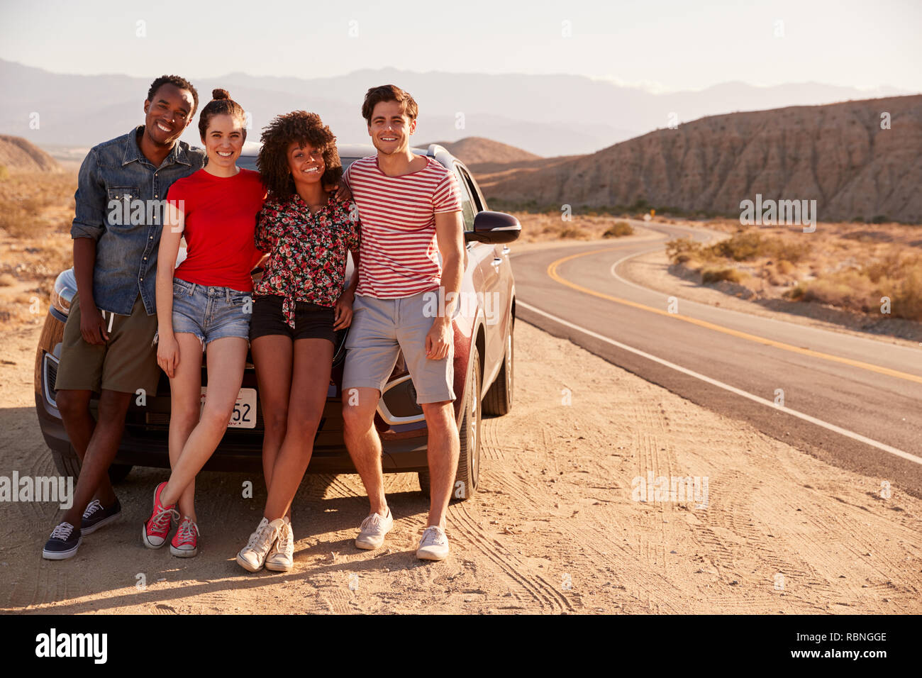 Giovani amici adulti in un viaggio su strada per prendersi una pausa dalla loro auto Foto Stock