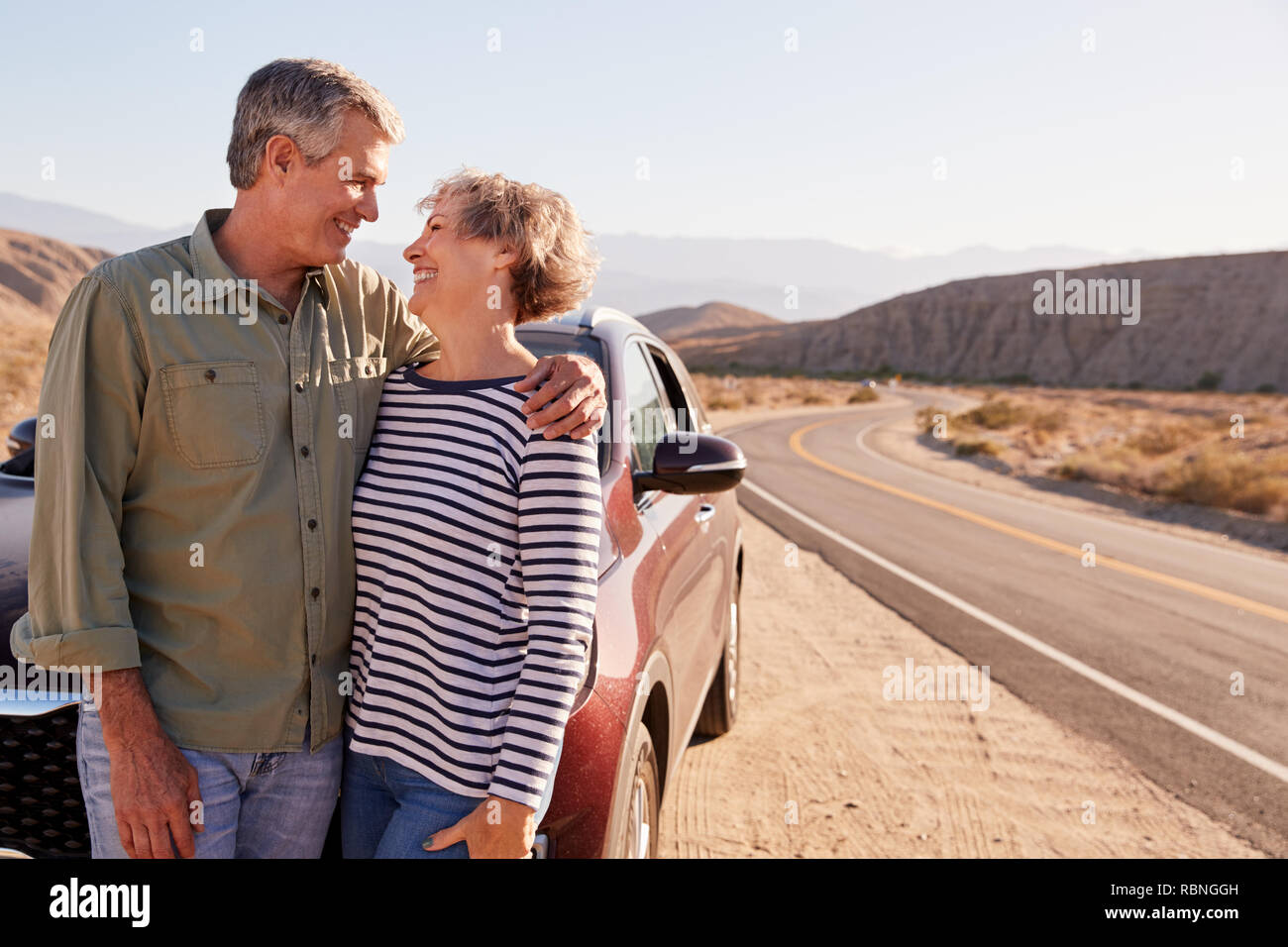 Coppia senior a guardare a ogni altro sulla strada del deserto Foto Stock