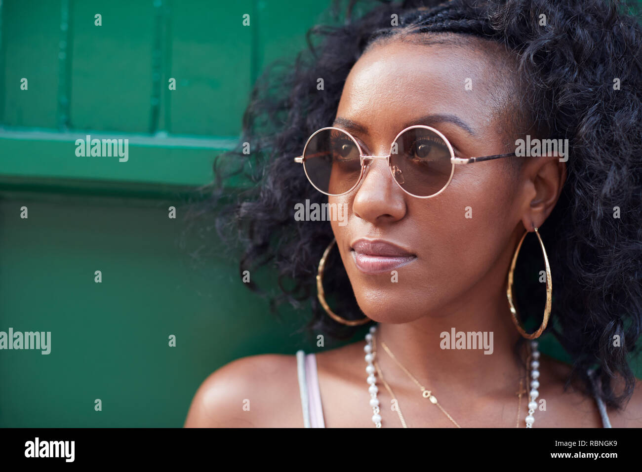 Moda giovane donna in canottiera e occhiali da sole e gioielli Foto Stock