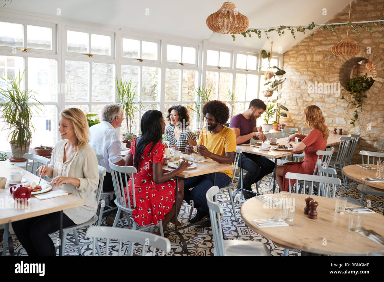 I clienti di mangiare in un ristorante affollato di giorno Foto Stock