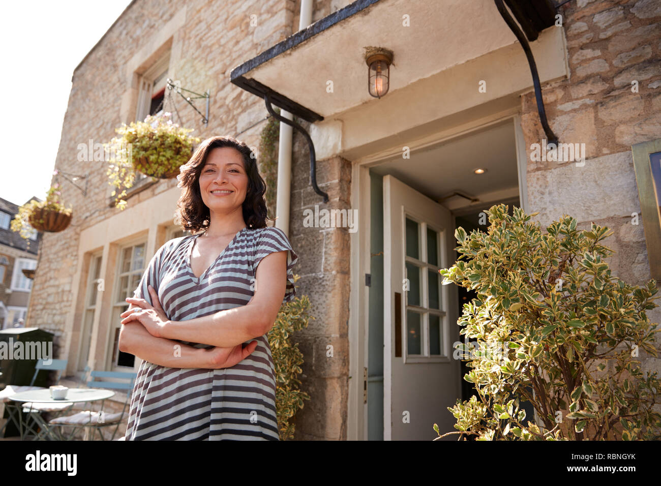 Femmina pub ristorante proprietario in piedi fuori il suo business Foto Stock