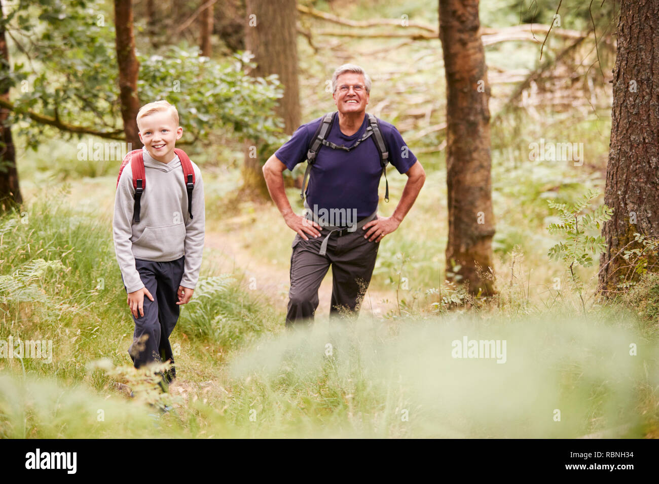 Nonno e nipote di prendere una pausa durante le escursioni in una foresta, il fuoco selettivo Foto Stock