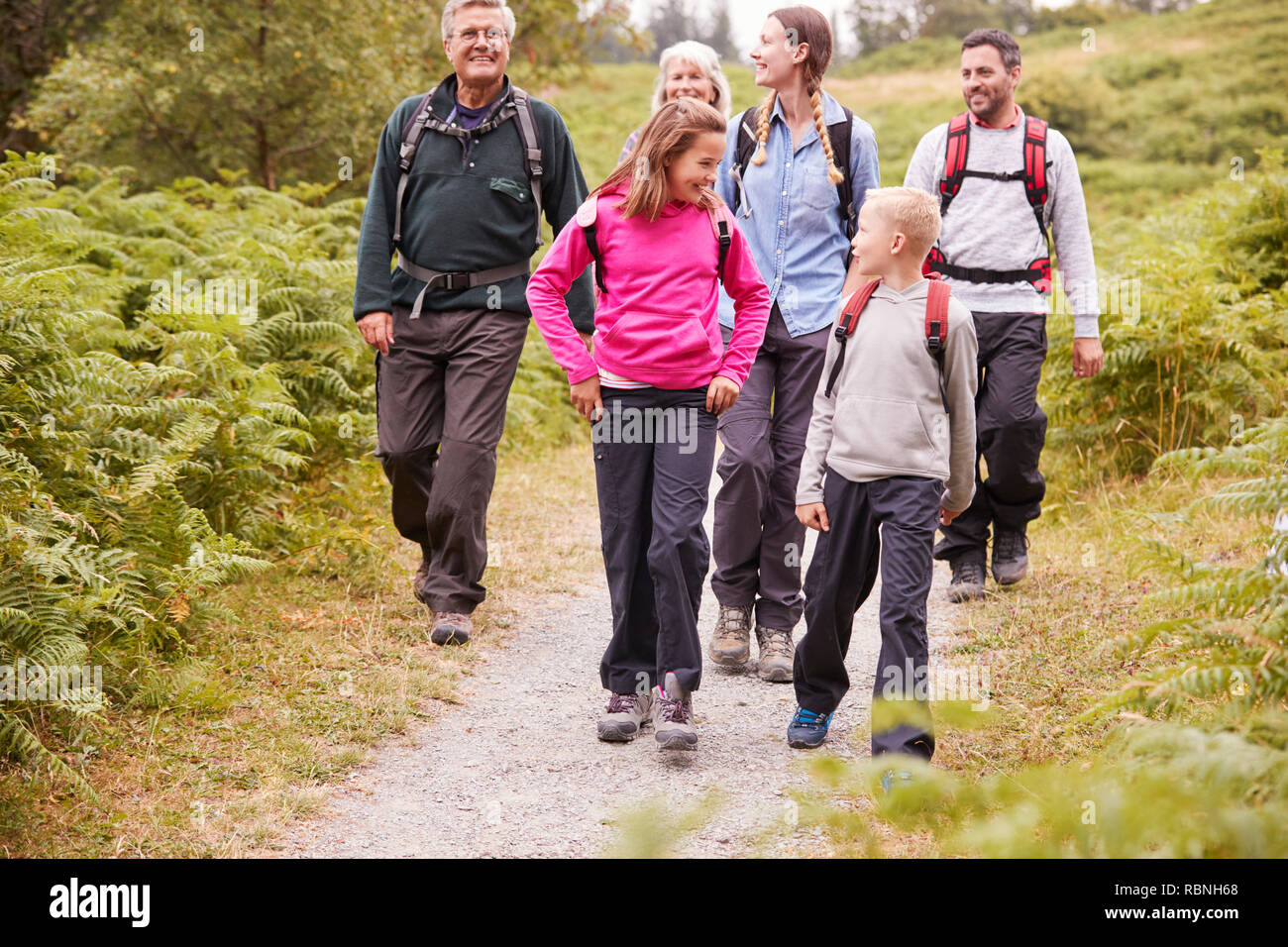 Generazione Multi family talk mentre passeggiate in campagna durante una vacanza in campeggio a piena lunghezza Foto Stock