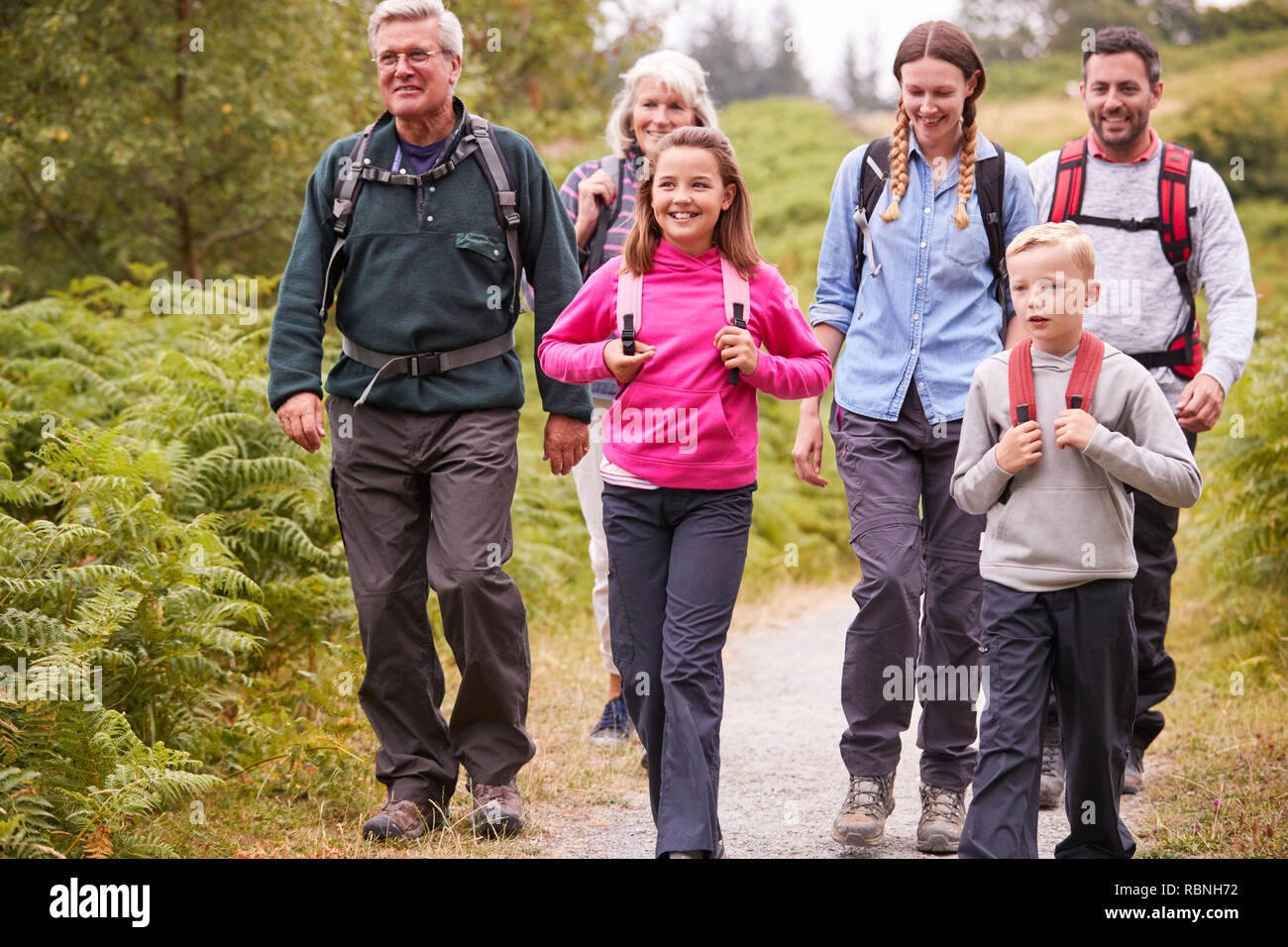 Multi generazione famiglia passeggiate in campagna durante una vacanza in campeggio,a piena lunghezza Foto Stock