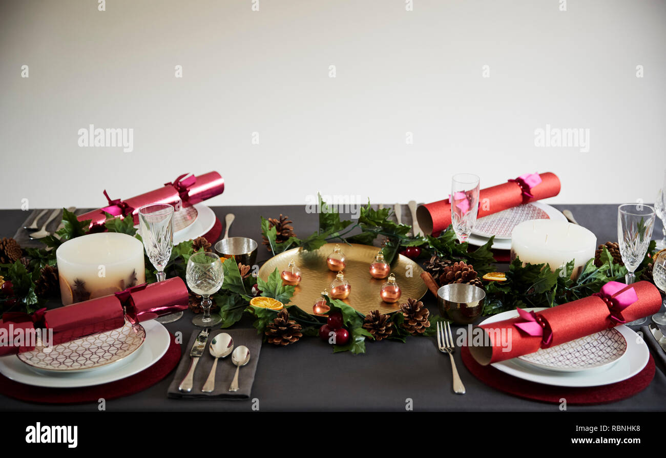 Natale decorato set tavolo per quattro persone, con Christmas Cracker disposte su piastre Foto Stock