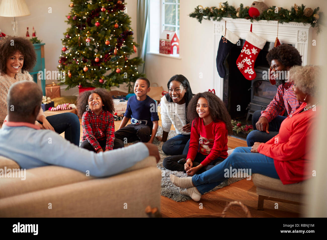 Multi generazione Famiglia seduta nel salotto di casa il giorno di Natale Foto Stock