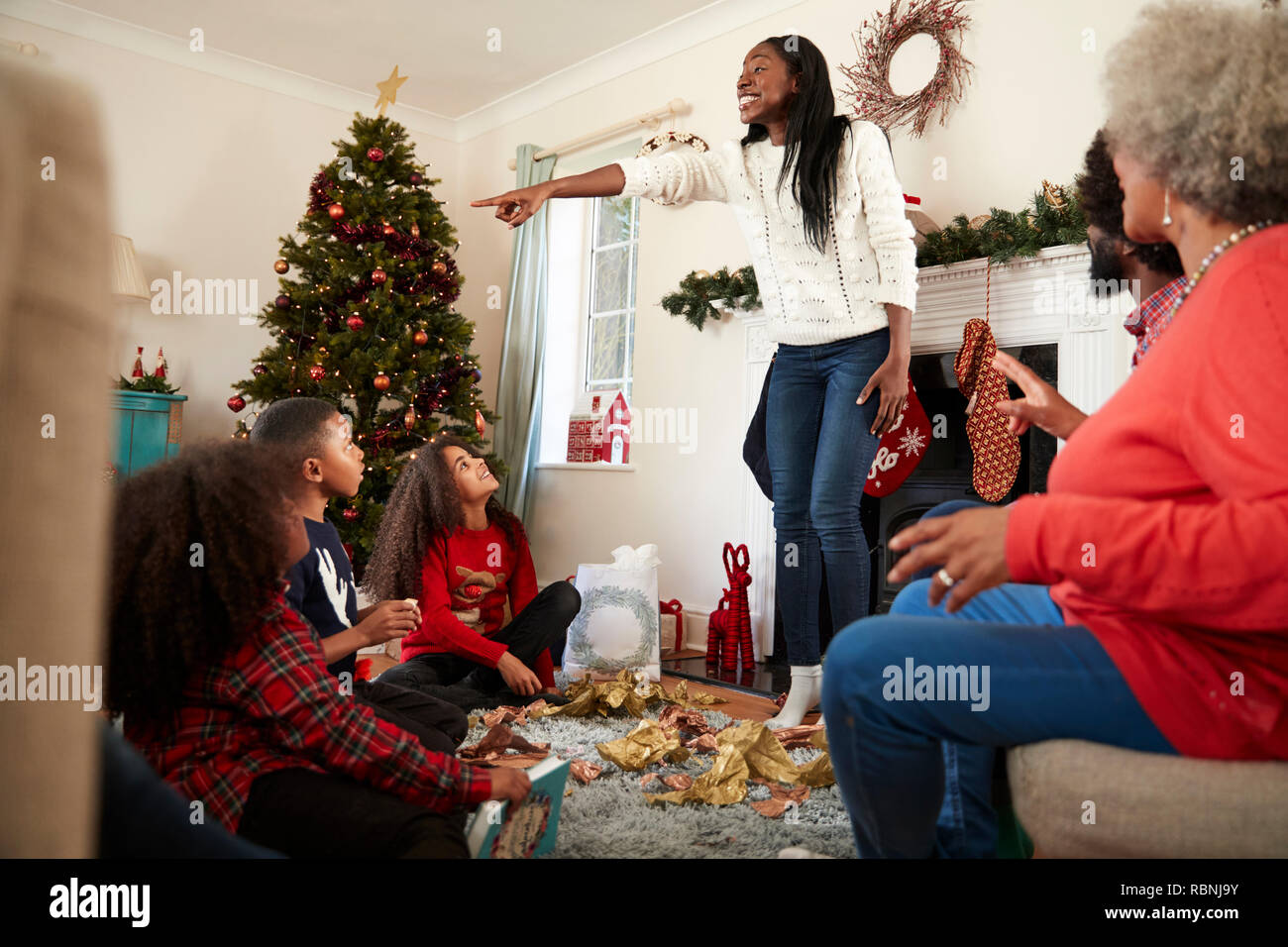 Generazione Multi Family Playing Game di corali come si festeggia il Natale a casa insieme Foto Stock