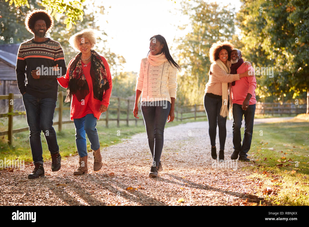 I genitori senior con adulto prole godendo di autunno a piedi in campagna insieme Foto Stock