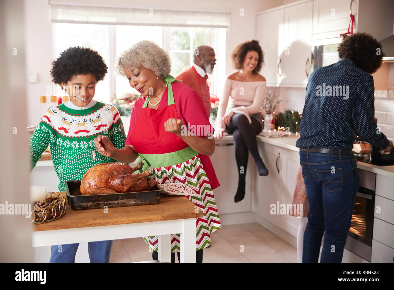 Razza mista, multi generazione parla di famiglia in cucina mentre si prepara la cena di Natale insieme Foto Stock