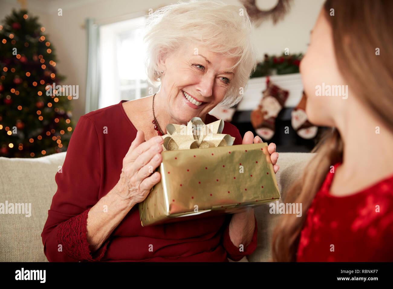 Nonna eccitato ricevere regali di Natale dal nipote a casa Foto stock -  Alamy