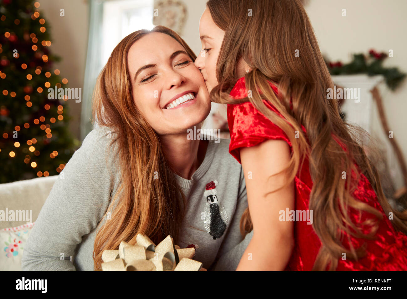 Excited donna riceve un regalo di Natale da uomo a casa Foto Stock