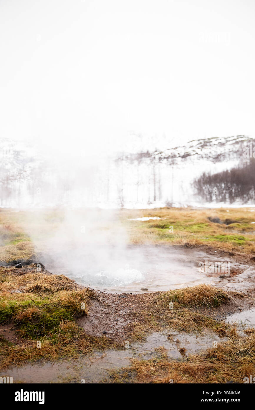 Il vapore passando da piscine geotermiche in campagna Islandese Foto Stock